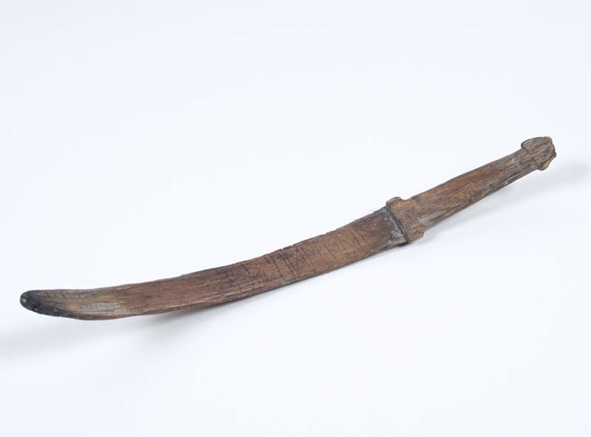 Kromgebogen miniatuurzwaard met runeninscriptie. De runeninscriptie wordt vooraf gegaan door een ruitvormig ornament. Runeninscriptie: EDAEBODA. De inscriptie kan geinterpreteerd worden als 'eed-bode', of 'drager van de eed'. Het zwaard had in de vroegmiddeleeuwse rechtspraak een belangrijke symbolische functie; een eed werd op een zwaard gezworen.