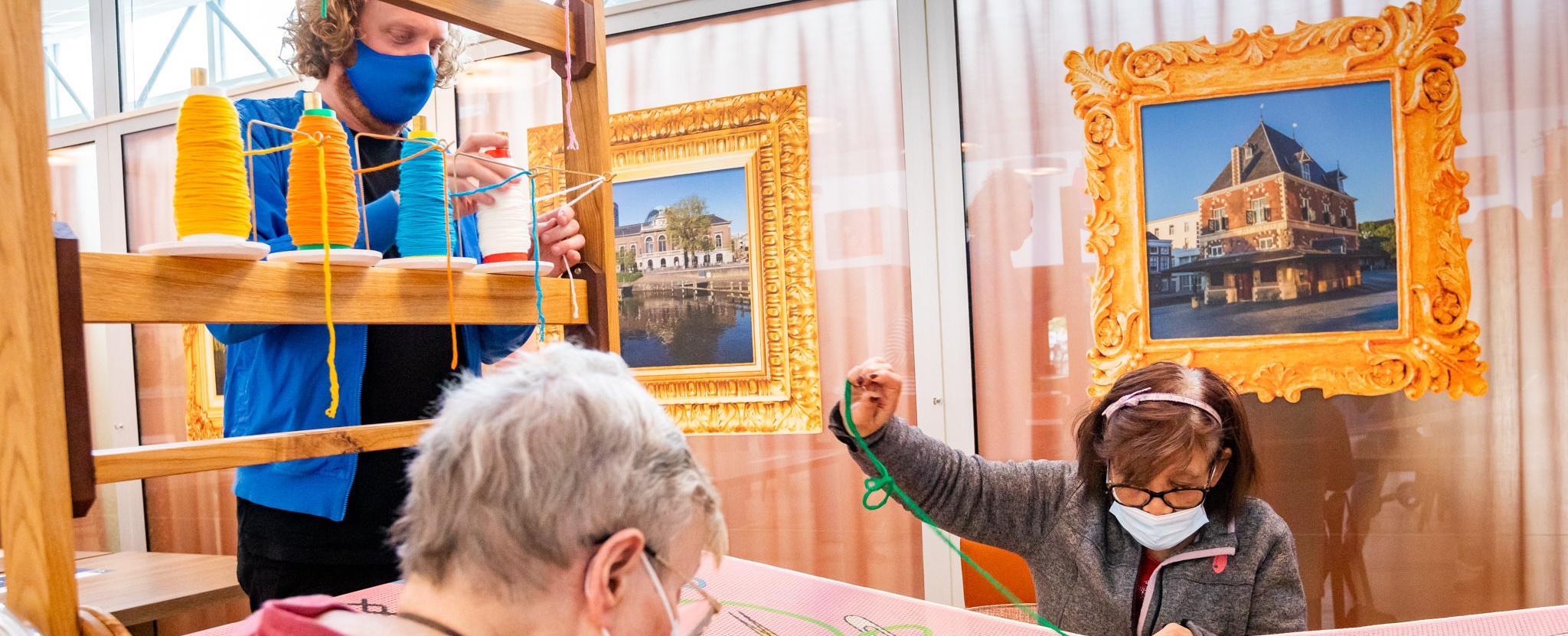 bewoners van wooncentrum greunshiem in leeuwarden leggen eerste steken aan de borduurinstallatie van floor nijdeken (links).  fo