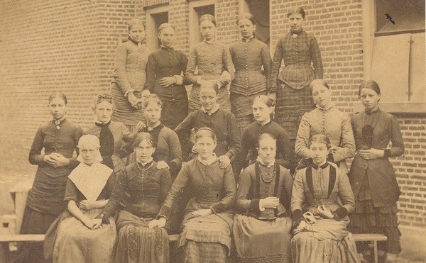 Leerlingen van de Normaalschool. Links voor zit een weesmeisje van het Old Burger Weeshuis, circa 1880, collectie Historisch Centrum Leeuwarden, nr. FDONDWSA168.