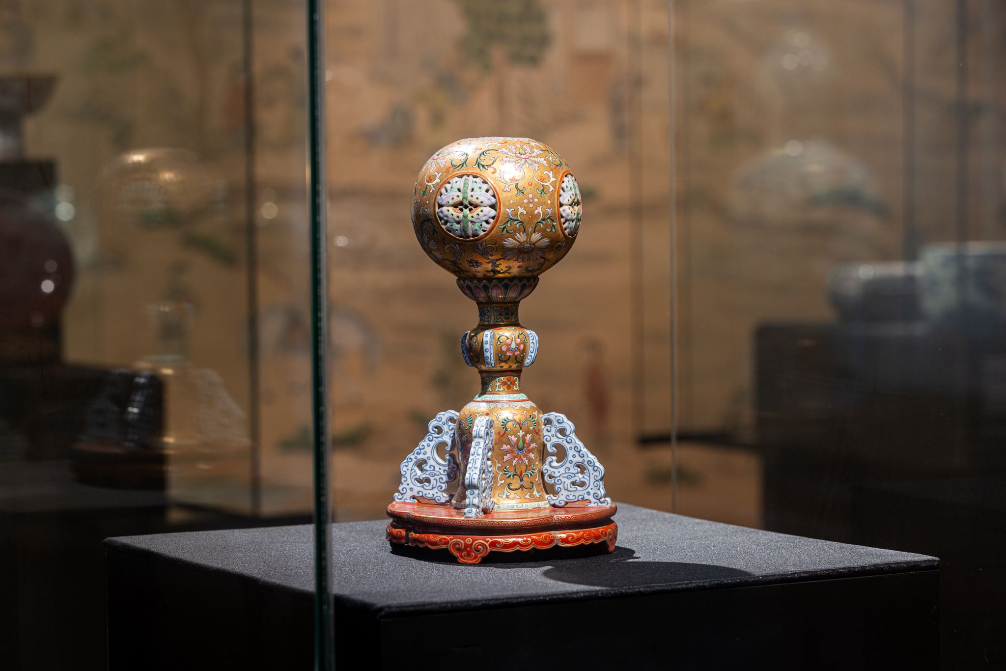 De hoedenparfumeerstandaard is een van de interessantste objecten uit de collectie van het Princessehof. Ooit was deze eigendom van de Chinese keizer Qianlong, die van 1736 tot 1795 over China heerste. De decoratie van de standaard is zeer gedetailleerd. In de tijd van keizer Qianlong werd het mode om porselein zo te decoreren dat het een ander materiaal leek te zijn, bijvoorbeeld hout of brons. Hoedenstandaard met floraal decor in verguldsel. China, Qing, Qianlong (1736 – 1795), porseleinfamille, rose.