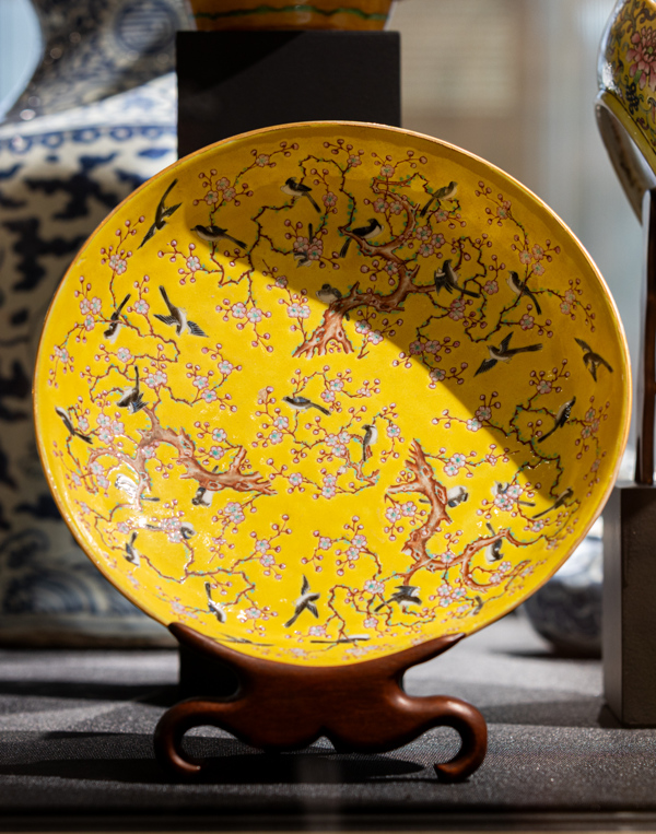 De kleuren van de eksters op dit bord contrasteren mooi met het heldere geel en het zachte roze van de bloesem. Sinds de Song-dynastie (960-1279) werden bloemen en vogels veelvuldig afgebeeld op Chinese painteringen. Eksters staan in China symbool voor voorspoed. Ze komen dan ook veel voor als decor op Chinees porselein, vooral in de Qing-dynastie (1644-1911). Bord met decor van eksters en prunus. China, Qing, Tongzhi (1862 – 1874), porseleinfamille, rose. De kleuren van de eksters op dit bord contrasteren mooi met het heldere geel en het zachte roze van de bloesem. Sinds de Song-dynastie (960-1279) werden bloemen en vogels veelvuldig afgebeeld op Chinese painteringen. Eksters staan in China symbool voor voorspoed. Ze komen dan ook veel voor als decor op Chinees porselein, vooral in de Qing-dynastie (1644-1911). Bord met decor van eksters en prunus. China, Qing, Tongzhi (1862 – 1874), porseleinfamille, rose.